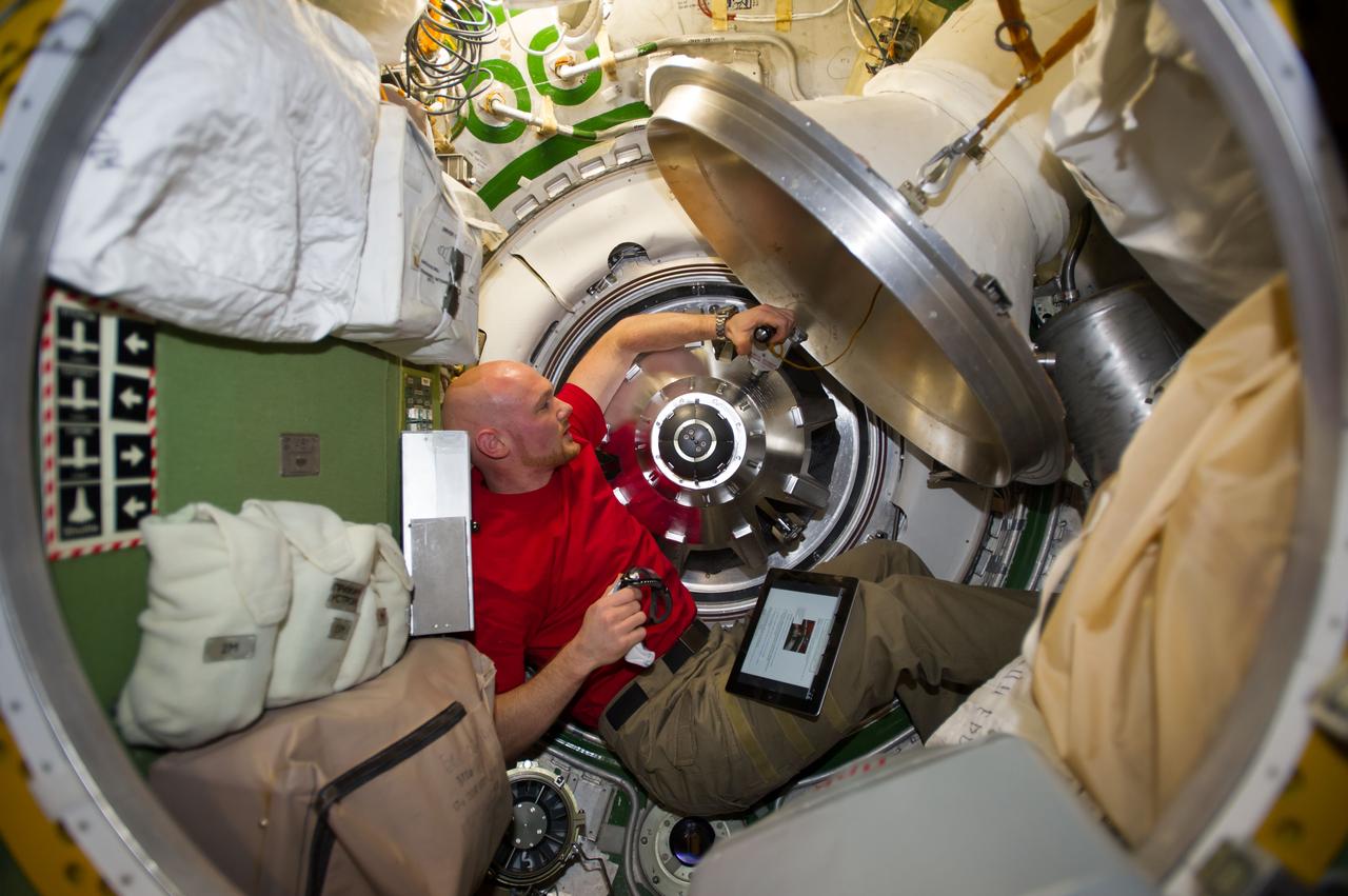 ISS040-E-091922 (13 Aug. 2014) --- European Space Agency astronaut Alexander Gerst, Expedition 40 flight engineer, prepares to remove the docking mechanism to gain access to the hatch of the newly attached "Georges Lemaitre" Automated Transfer Vehicle-5 (ATV-5).