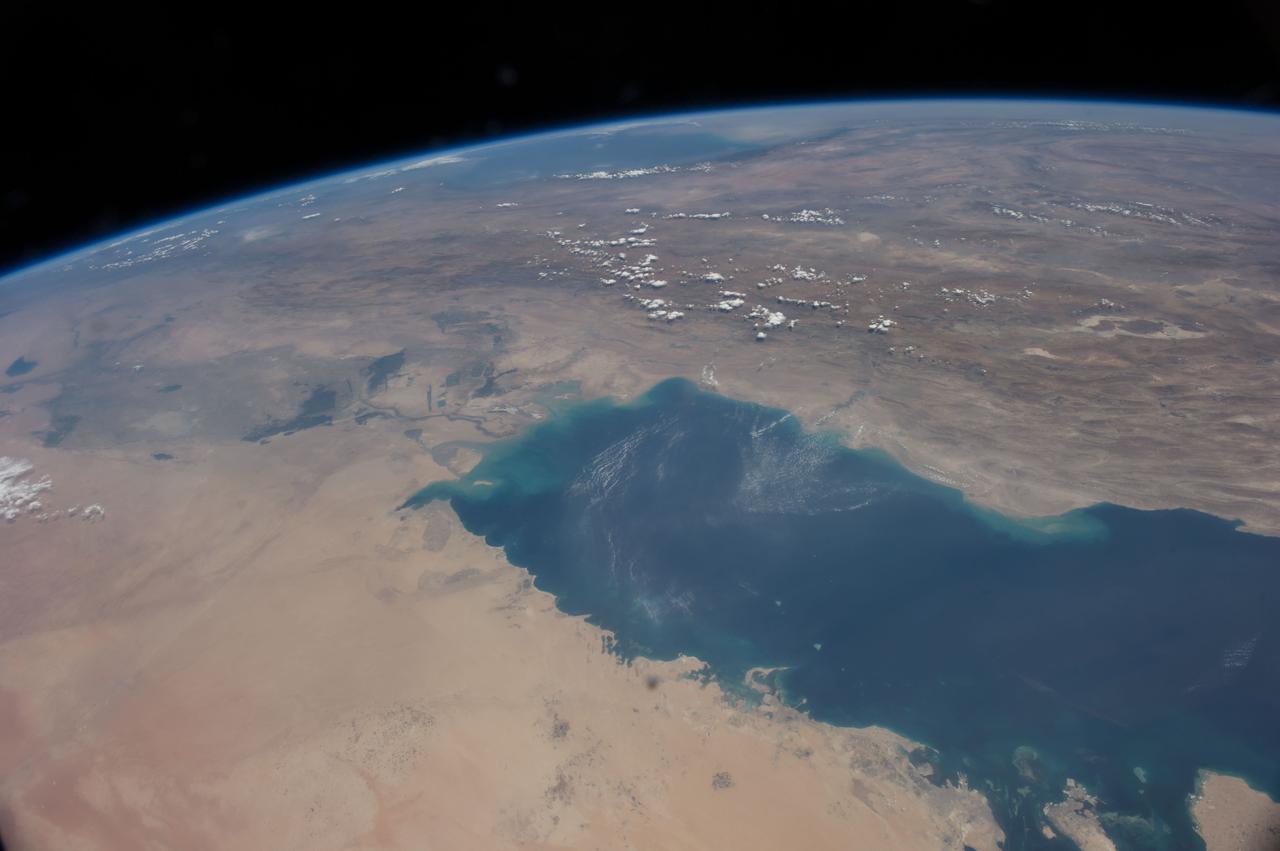 ISS040-E-106243 (25 Aug. 2014) --- This panorama view, photographed by an Expedition 40 crew member on the International Space Station, shows the tropical blue waters of the Persian Gulf. Strong north winds often blow in summer, churning up dust from the entire length of the desert surfaces of the Tigris and Euphrates valleys (top left). Dust partly obscures the hundreds of kilometers of Iraq?s light-green agricultural lands along these rivers (left). The Caspian Sea cuts the horizon.