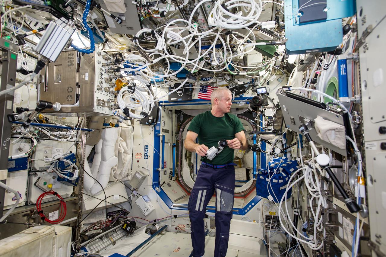 ISS040-E-123259 (2 Sept. 2014) --- NASA astronaut Steve Swanson, Expedition 40 commander, prepares to set up the Portable Pulmonary Function System hardware for Sprint VO2max sessions in the Destiny laboratory of the International Space Station. The Sprint experiment measures the effectiveness of high-intensity, low-volume exercise training in minimizing the loss of muscle mass and bone density that occurs during spaceflight.