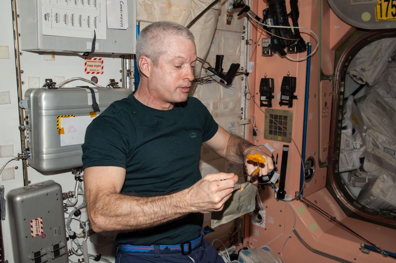 ISS040-E-123640 (7 Sept. 2014) --- NASA astronaut Steve Swanson, Expedition 40 commander, eats a citrus fruit salad in the Unity node of the International Space Station.