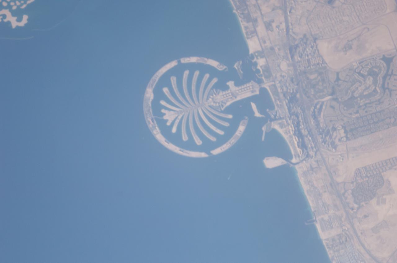 ISS040-E-125332 (4 Sept. 2014) --- Palm Jumeirah, protruding off the Persian Gulf Coast of Dubai in the United Arab Emirates, is featured in this 800mm photograph, taken by one of the Expedition 40 crew members aboard the International Space Station. The municipality of Dubai is the largest city of the Persian Gulf emirate of the same name, and has built a global reputation for large-scale developments and architectural works. Among the most visible of these developments ? particularly from the perspective of crew members onboard the space station ? are three man-made archipelagos. The two Palm Islands (Palm Jumeirah and Palm Jebel Ali, which is not in this frame) appear as stylized palm trees when viewed from above. The World Islands evoke a rough map of the world from an air- or space-borne perspective. A very small part of the World Islands is seen in upper left corner.