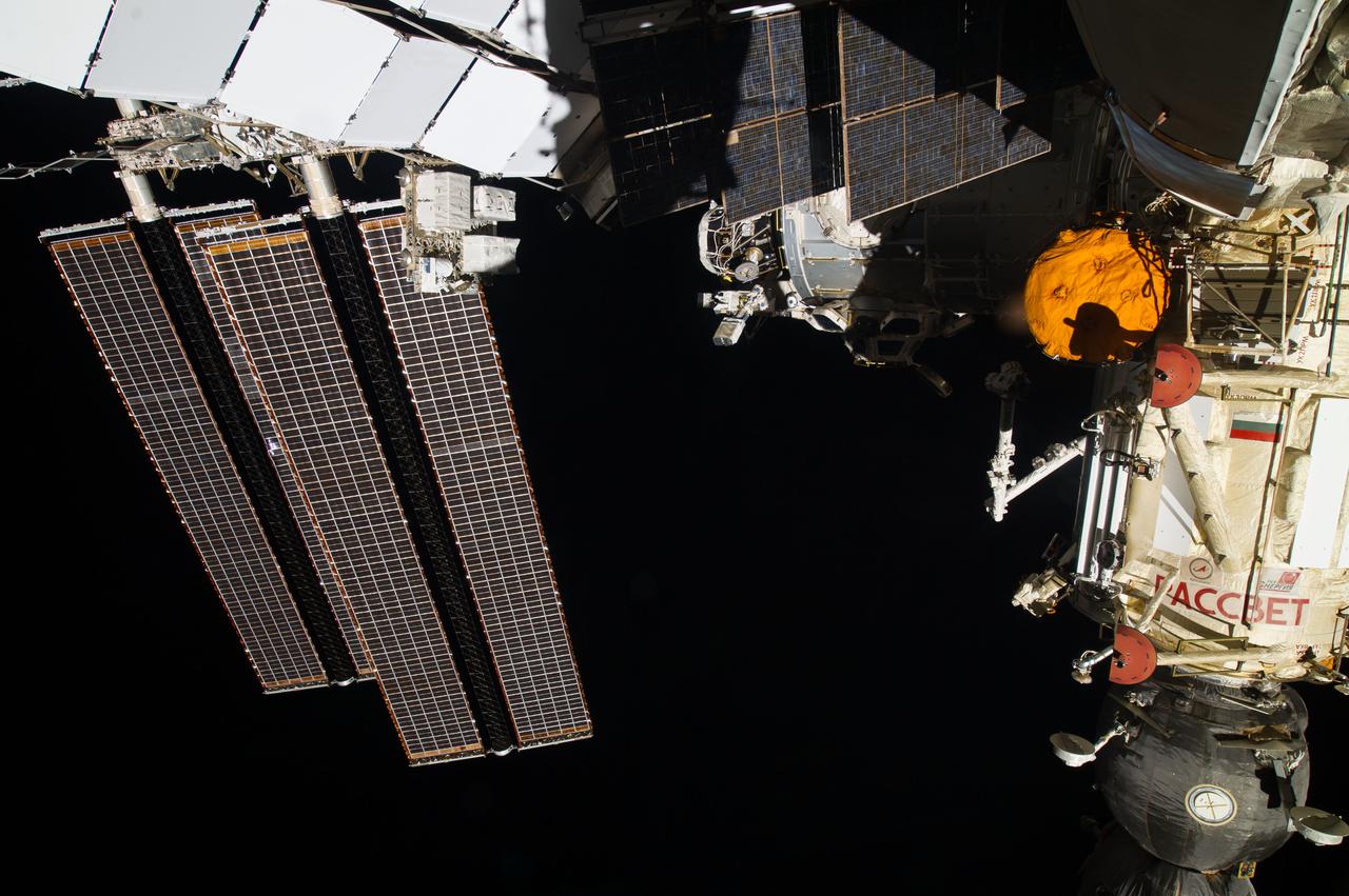 ISS040-E-128792 (6 Sept. 2014) --- The NanoRacks Cubesat deployer, attached to the Japan Aerospace Exploration Agency’s Kibo robotic arm, can be seen in upper center of this photograph, exposed by one of the Expedition 40 crew members aboard the International Space Station, flying 228 nautical miles above Earth on Sept. 6, 2014. Surrounded by a variety of solar array panels supporting various components of the orbital outpost is the Cupola, partly in darkness. Soyuz 39 TMA-13M is docked to Rassvet at right.