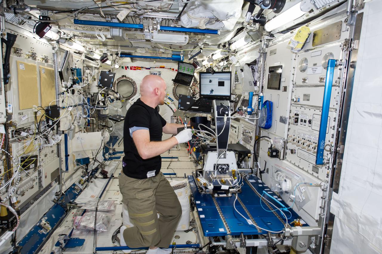 ISS040-E-130232 (9 Sept. 2014) --- European Space Agency astronaut Alexander Gerst, Expedition 40 flight engineer, installs a microscope for the Cell Mechanosensing-2 experiment in the Kibo laboratory of the International Space Station. The Japanese experiment, which is conducted in Kibo’s Kobairo rack, seeks to identify gravity sensors in cells that may change the expression of key proteins and genes and allowing muscles to atrophy in microgravity.