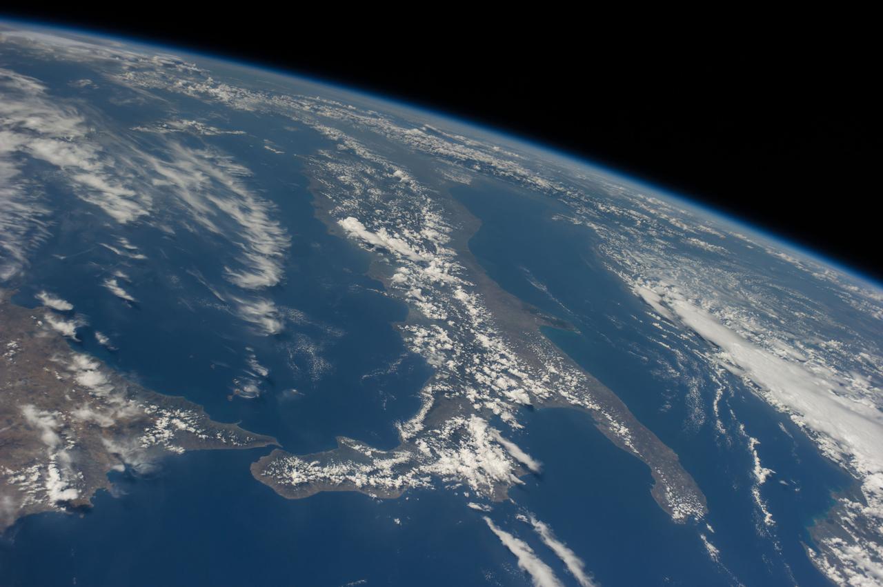 ISS040-E-131380 (8 Sept. 2014) --- Collections of clouds hug Sicily (lower left) and Italy, which runs vertically through the center of this oblique scene, exposed by one the Expedition 40 crew members aboard the International Space Station at an altitude of 221 nautical miles.
