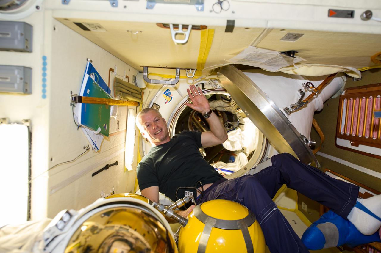 ISS040-E-139784 (10 Sept. 2014) --- In the Poisk Mini-Research Module 2 (MRM2), NASA astronaut Steve Swanson, Expedition 40 commander, waves good-bye prior to entering the Soyuz TMA-12M capsule which will return him back to Earth along with Russian cosmonauts Alexander Skvortsov and Oleg Artemyev, both flight engineers. Undocking occurred at 7:01 p.m. (EDT) on Sept. 10, 2014.