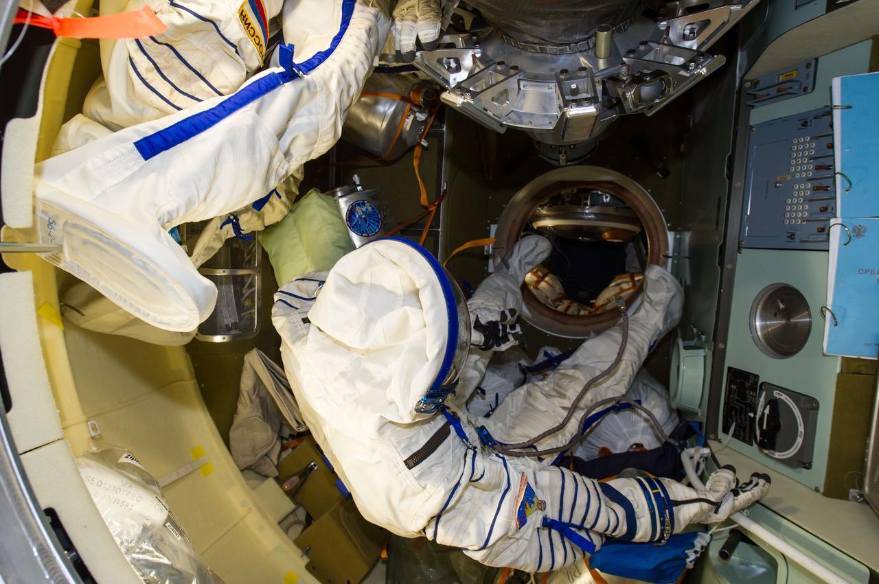 ISS040-E-139788 (10 Sept. 2014) --- Unoccupied Russian Sokol launch and entry suits, photographed by an Expedition 40 crew member, float freely in the International Space Station’s Poisk Mini-Research Module 2 (MRM2).