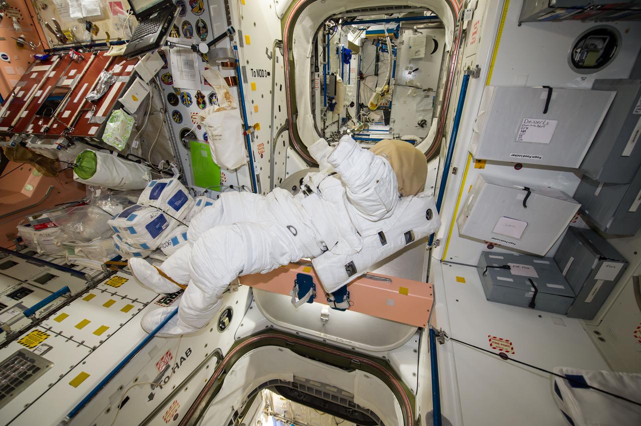 ISS041-E-011851 (15 Sept. 2014) --- An unoccupied Extravehicular Mobility Unit (EMU) spacesuit, photographed by an Expedition 41 crew member, floats freely near the hatches inside the Harmony node of the International Space Station.