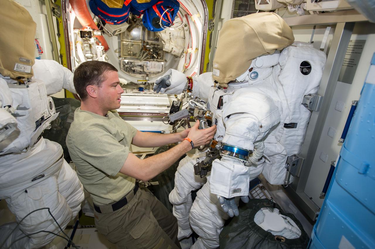 ISS041-E-017029 (19 Sept. 2014) --- NASA astronaut Reid Wiseman, Expedition 41 flight engineer, works with tools and equipment on an Extravehicular Mobility Unit (EMU) spacesuit in the Quest airlock of the International Space Station in preparation for two spacewalks scheduled in October 2014.