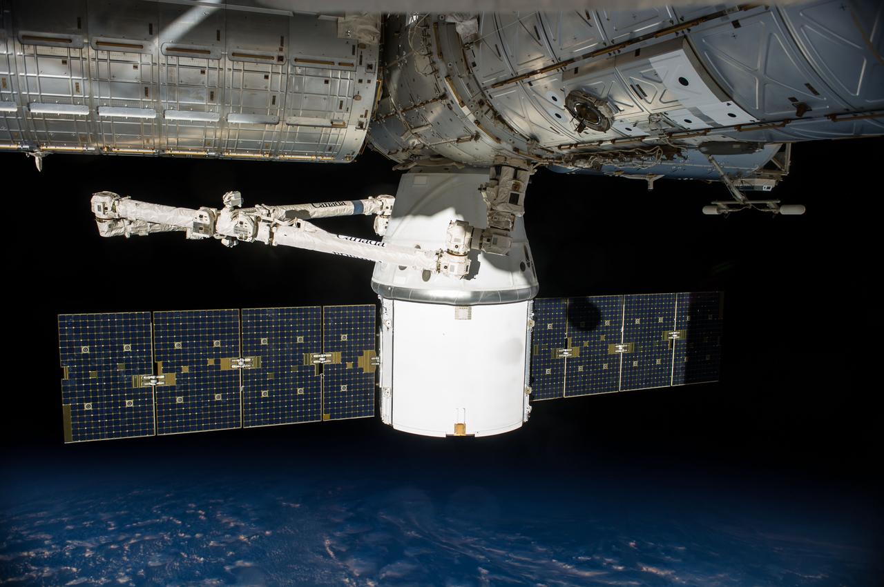 ISS041-E-033462 (24 Sept. 2014) --- SpaceX's uncrewed Dragon cargo spacecraft is docked to the International Space Station after arriving on Sept. 23 with a load of supplies and equipment for the three crew members currently onboard the orbital outpost and the three who will join them soon.