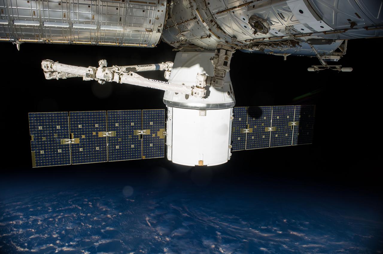 ISS041-E-033463 (24 Sept. 2014) --- SpaceX's uncrewed Dragon cargo spacecraft is docked to the International Space Station after arriving on Sept. 23 with a load of supplies and equipment for the three crew members currently onboard the orbital outpost and the three who will join them soon.