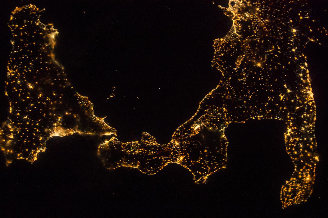 ISS041-E-045376 (27 Sept. 2014) --- One of the Expedition 41 crew members aboard the International Space Station, flying 221 nautical miles above Earth, recorded this night view over southern Italy on Sept. 27, 2014. South is at the bottom of the picture. Italy's "boot" (right) and Sicily are featured in the 28mm image.