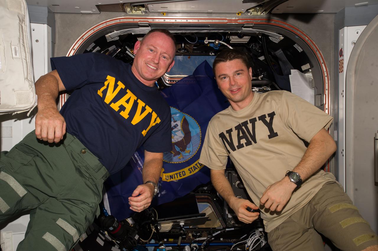 ISS041-E-046056 (28 Sept. 2014) --- NASA astronauts Barry Wilmore (Captain, U.S. Navy) (left) and Reid Wiseman (Commander, U.S. Navy), both Expedition 41 flight engineers, pose for a photo near the hatch between the Tranquility node and the Cupola of the International Space Station.
