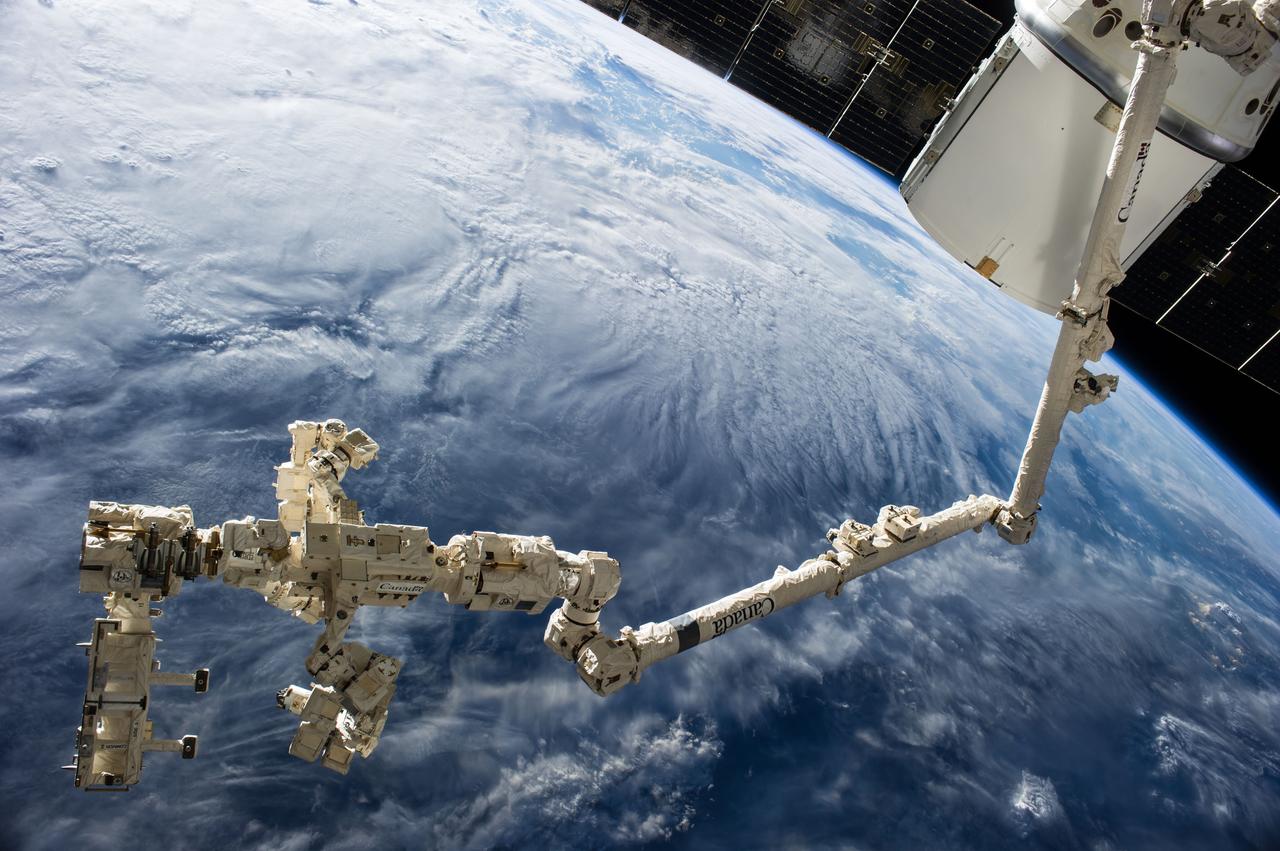 ISS041-E-049099 (30 Sept. 2014) --- The International Space Station?s Canadarm2 and Dextre, also known as the Special Purpose Dextrous Manipulator (SPDM), carry the Rapidscat instrument assembly after removing it from the trunk of the SpaceX Dragon cargo ship (upper right), which is currently docked to the nadir port of the Harmony node. The Rapidscat was then maneuvered for attachment to the nadir adapter that is affixed to the station?s Columbus laboratory.