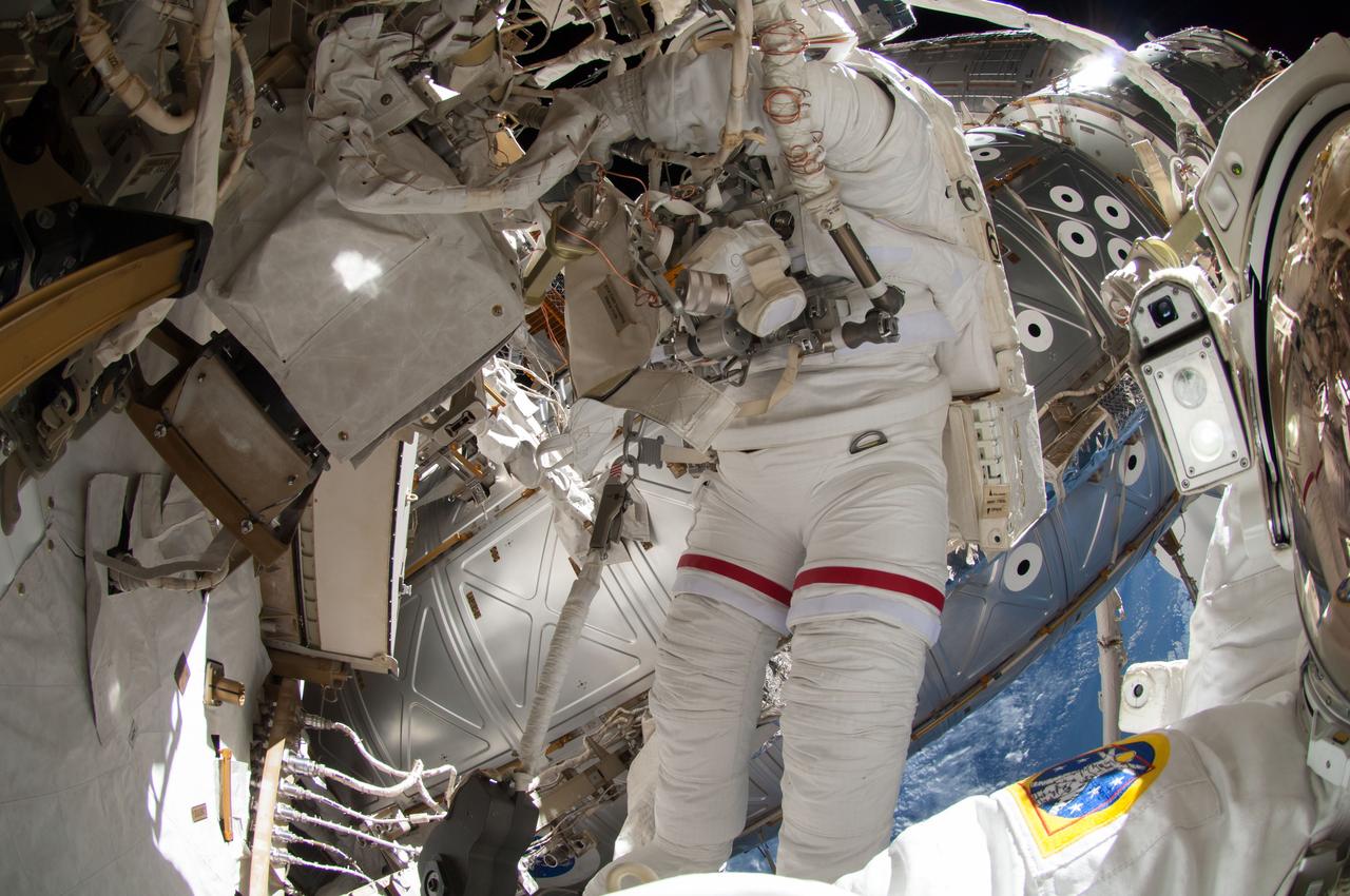 ISS041-E-067002 (7 Oct. 2014) --- NASA astronaut Reid Wiseman, Expedition 41 flight engineer, participates in a session of extravehicular activity (EVA) as work continues on the International Space Station. During the six-hour, 13-minute spacewalk, Wiseman and European Space Agency astronaut Alexander Gerst (out of frame), flight engineer, worked outside the space station's Quest airlock relocating a failed cooling pump to external stowage and installing gear that provides back up power to external robotics equipment.