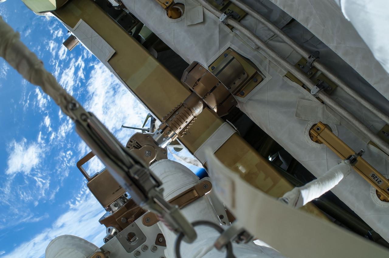 ISS041-E-067002 (7 Oct. 2014) --- NASA astronaut Reid Wiseman, Expedition 41 flight engineer, participates in a session of extravehicular activity (EVA) as work continues on the International Space Station. During the six-hour, 13-minute spacewalk, Wiseman and European Space Agency astronaut Alexander Gerst (out of frame), flight engineer, worked outside the space station's Quest airlock relocating a failed cooling pump to external stowage and installing gear that provides back up power to external robotics equipment.