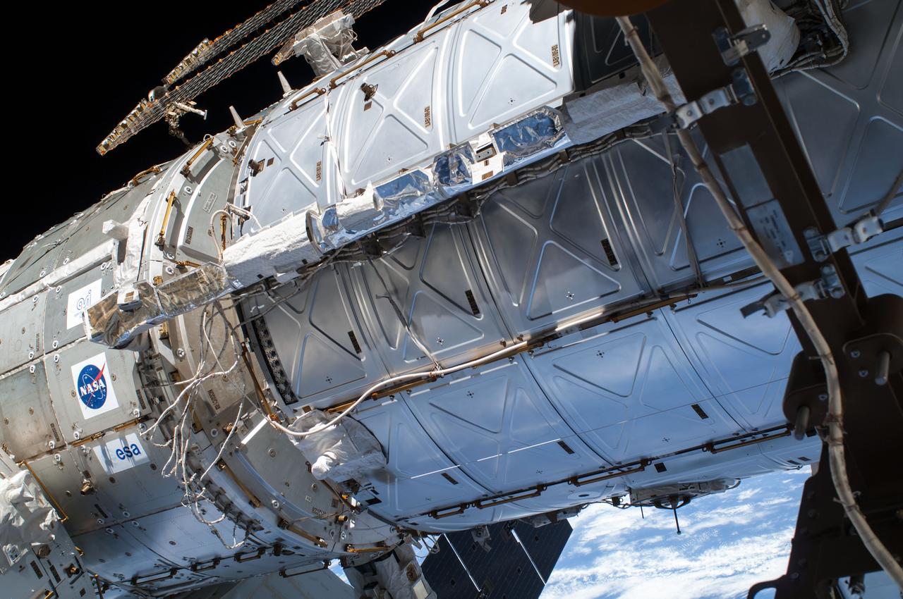 ISS041-E-067002 (7 Oct. 2014) --- NASA astronaut Reid Wiseman, Expedition 41 flight engineer, participates in a session of extravehicular activity (EVA) as work continues on the International Space Station. During the six-hour, 13-minute spacewalk, Wiseman and European Space Agency astronaut Alexander Gerst (out of frame), flight engineer, worked outside the space station's Quest airlock relocating a failed cooling pump to external stowage and installing gear that provides back up power to external robotics equipment.