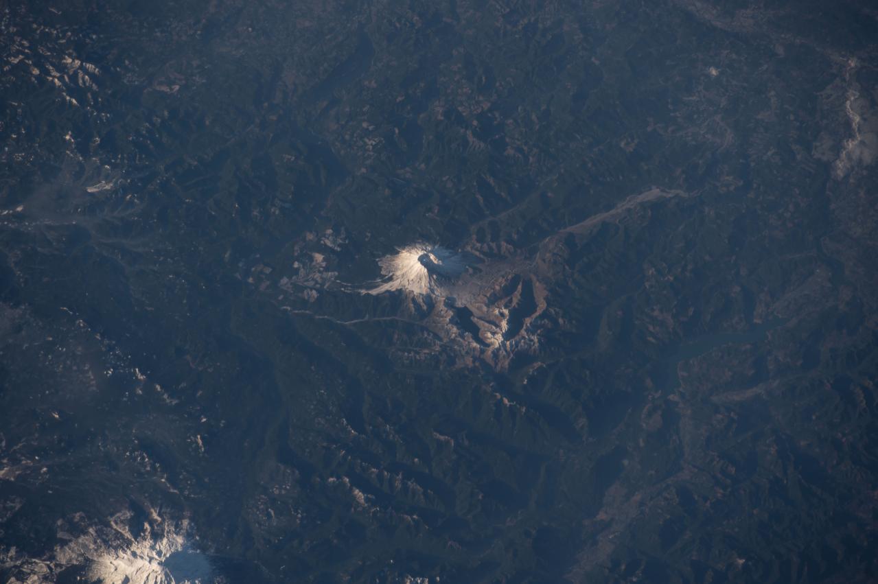 Earth observation taken by the Expedition 42 crew aboard the ISS. Mt. St. Helens (center) and Mt. Rainier, Washington. Image was released by astronaut on Instagram.