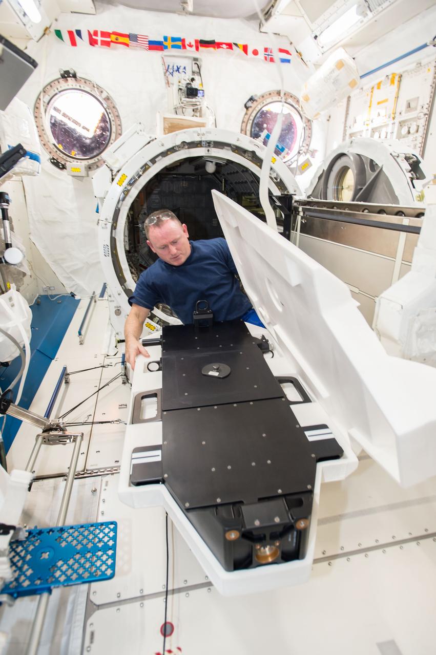 iss042e015943 (11/26/2014) --- Commander Barry Wilmore unpacks the Cyclops launch platform for installation on the Japanese Experiment Module Airlock (JEMAL) slide table. The Cyclops platform, also known as the Space Station Integrated Kinetic Launcher for Orbital Payload Systems (SSIKLOPS), holds and ejects nanosatellites from outside the ISS.