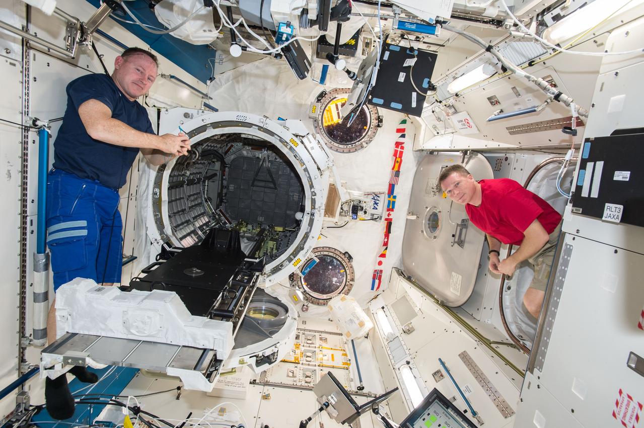 iss042e015971 (11/26/2011) --- NASA astronauts Barry Wilmore and Terry Virts are photographed during operations to install the Cyclops launch platform on the Japanese Experiment Module Airlock (JEMAL) slide table. The Cyclops platform, also known as the Space Station Integrated Kinetic Launcher for Orbital Payload Systems (SSIKLOPS), holds and ejects nanosatellites from outside the ISS.