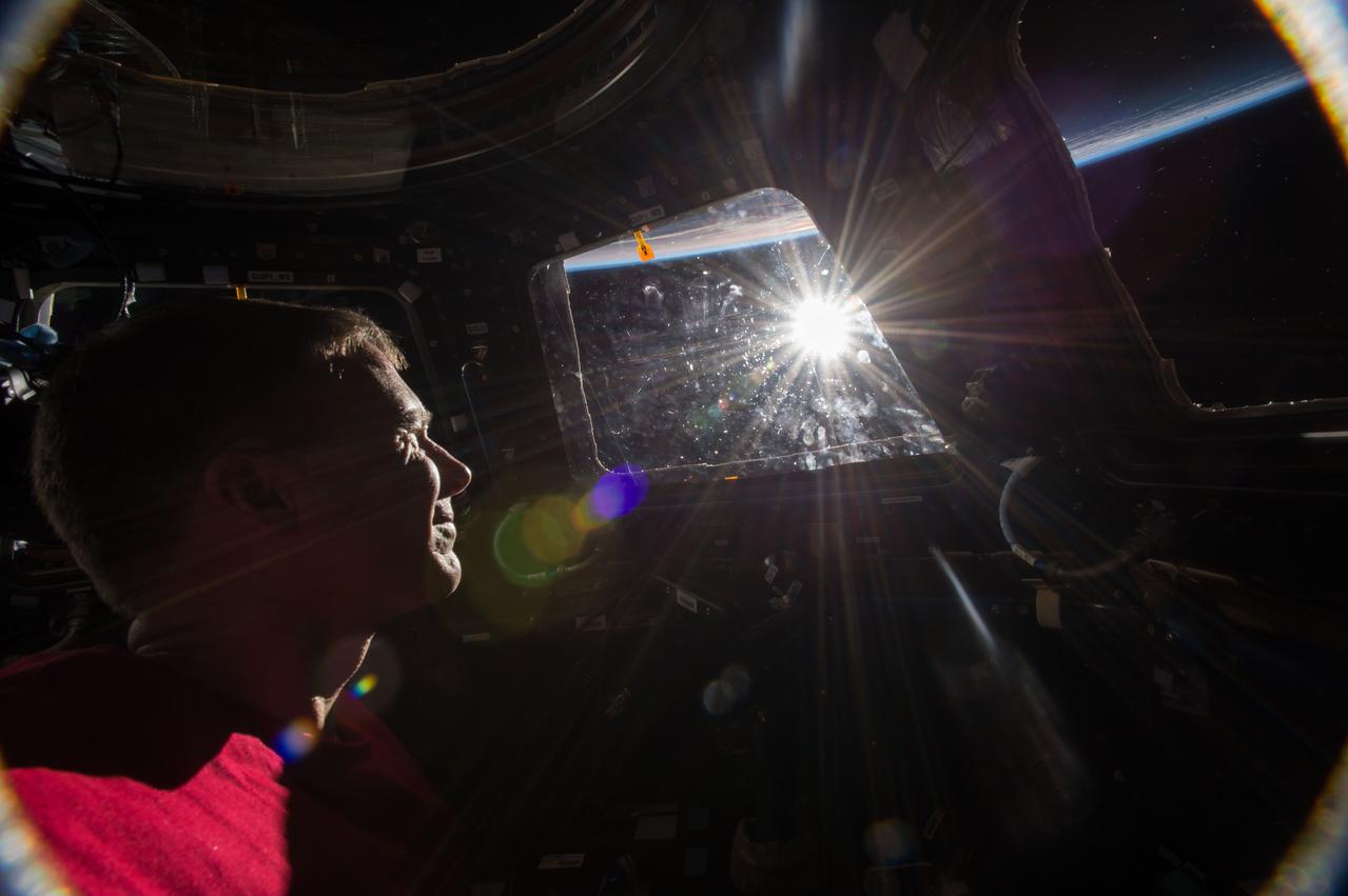 ISS042e016586 (11/26/2014) --- NASA astronaut Terry Virts in the International Space Station on Earth sunrise Nov. 26, 2014 looks through the cupola window while checking the "dosimeter". The cupola allows the crew 360 degree vision around the station for both photos and operating the Canada arm to pull spacecraft up to the station ports.