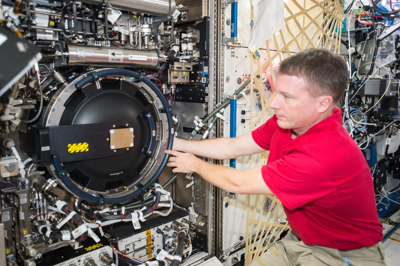 ISS042E017804 (11/28/2014) --- US Astronaut Terry Virts works to rotate out the Optics Bench during Combustion Integrated Rack (CIR) Imaging Package reconfiguration in the Destiny U.S. Laboratory of the International Space Station.