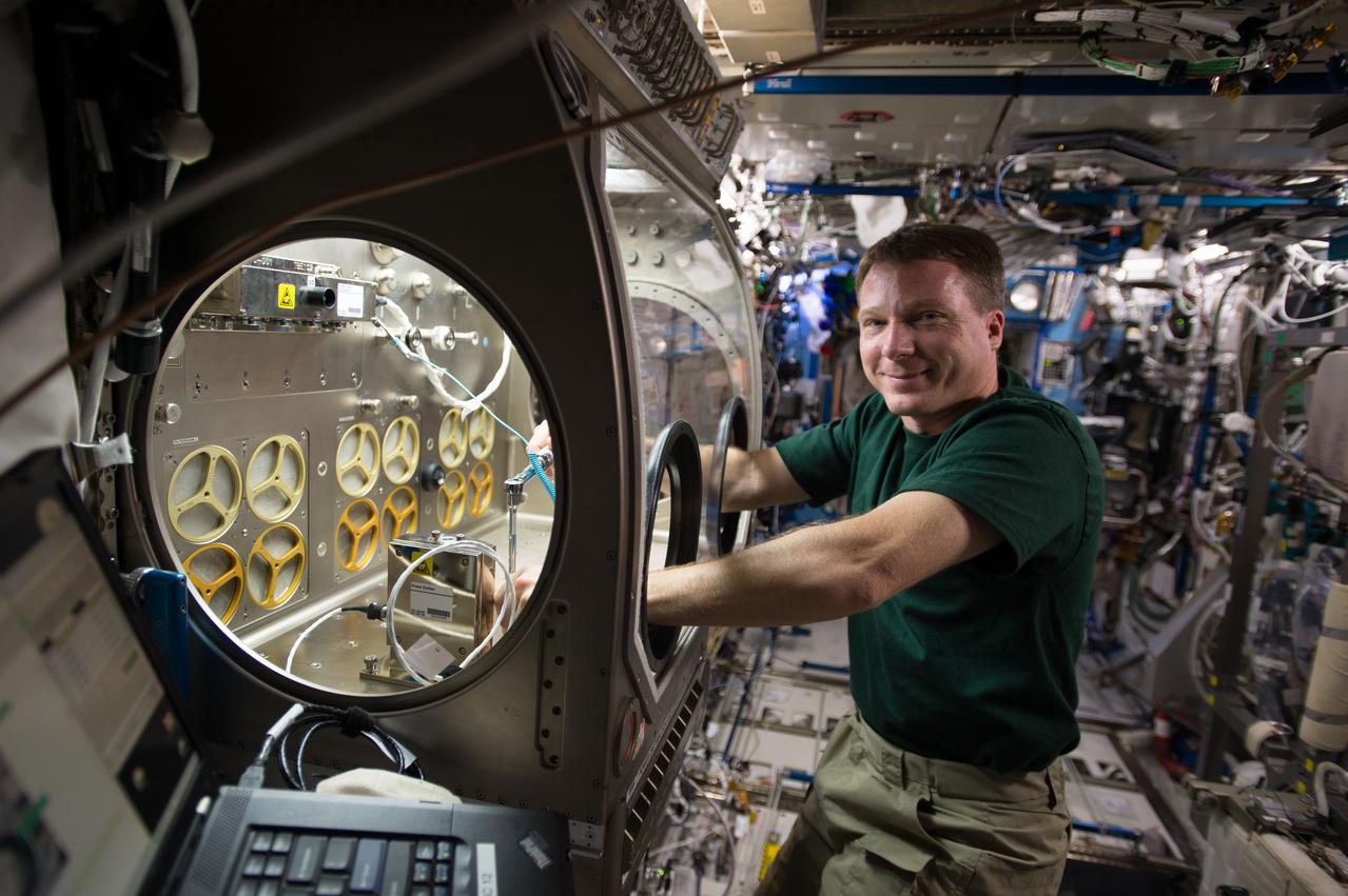iss042e046523 (12/16/14) --- Expedition 42 Flight Engineer Terry Virts of NASA is seen here on 16 December 2014 setting up the station’s Microgravity Science Glovebox for the upcoming Micro-5 experiment.  Micro-5 will use roundworms as a model organism with the microbe Salmonella typhimurium, which causes food poisoning in humans, to better understand the risks of in-flight infections in space explorers.