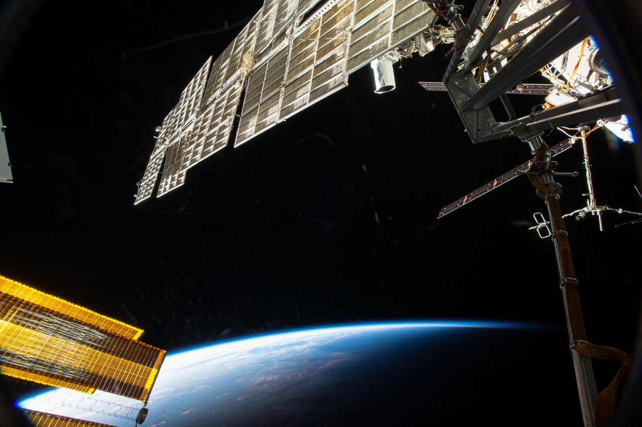 ISS042E094136 (01/01/2015) --- Station solar arrays from the Russian Zarya module (top) and main arrays (bottom left) dominate this picturesque view as the International Space Station passes over a darkening Earth below. The combination of arrays on station power the multitude of systems onboard providing life support and functionality to a crew working on scientific research off the Earth, for the Earth.