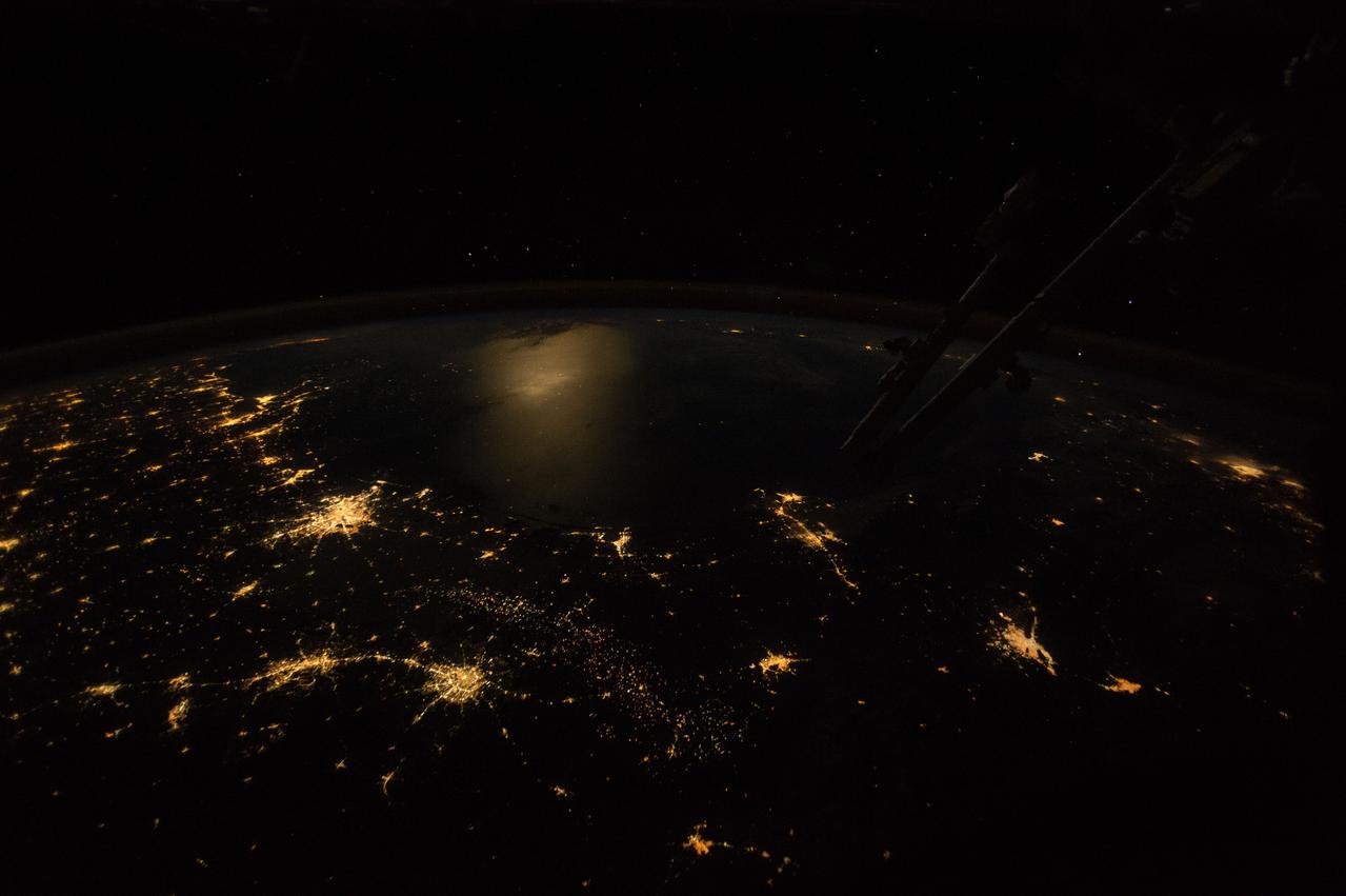 ISS042E241898 (02/11/2015) --- Texas and the Gulf Coast at night as seen by the International Space Stations Earth observation cameras. This wide-angle, nighttime image was taken by astronauts looking out southeastward over the Gulf of Mexico. Lower center left shows the twin lights of San Antonio Texas with a short string of lights to Austin (further left). Houston, the home of the Johnson Space Center is the brightest directly above (Center left). Moonlight reflects diffusely off the waters of the gulf (image center left) making the largest but diffused illuminated area in the image. The sharp edge of light patterns of coastal cities trace out the long curve of the gulf shoreline—from New Orleans at the mouth of the Mississippi River, to Houston (both image left), to Brownsville (image center) in the westernmost gulf. City lights at great distances in Florida (image top left) and on Mexico’s Yucatán peninsula (image center right) suggest the full extent of the gulf basin, more than 930 miles, from Brownsville to Florida.