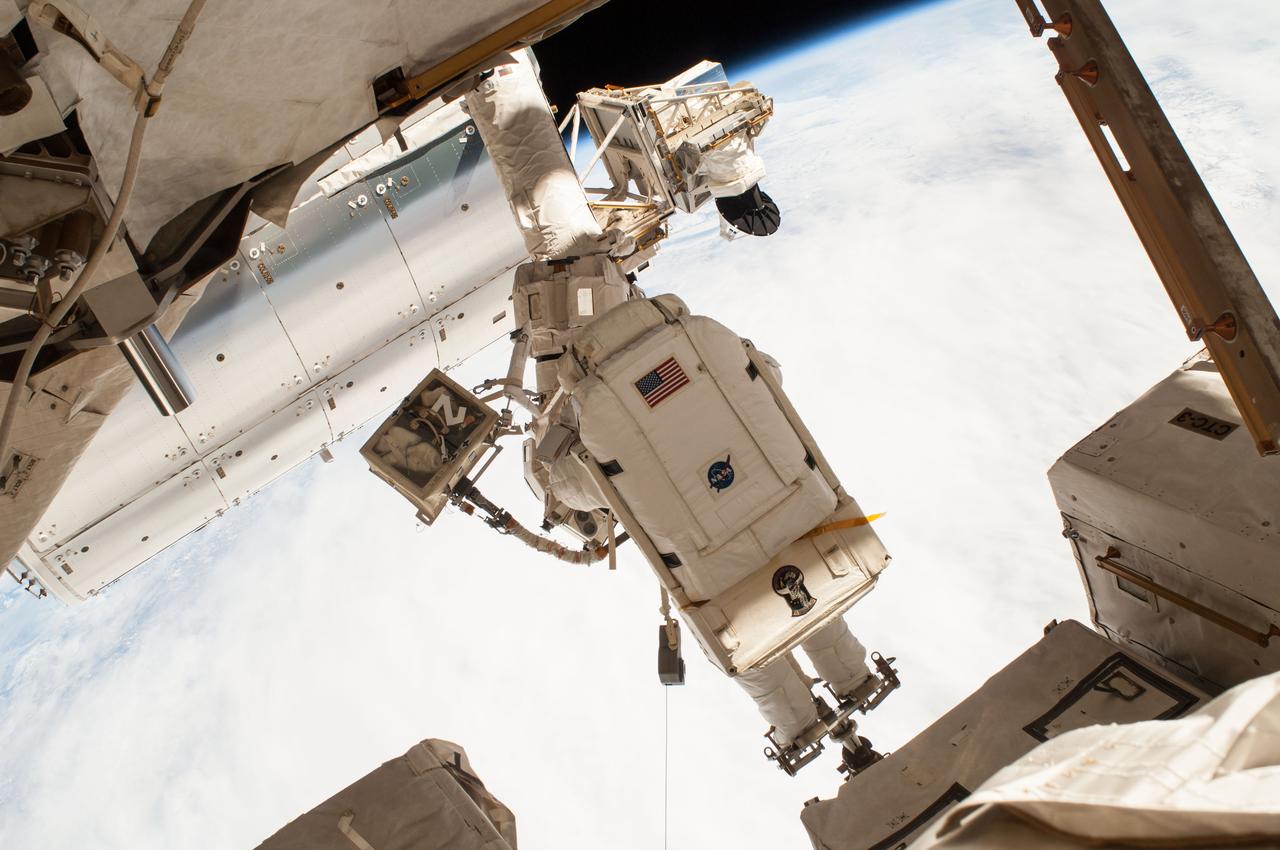 ISS042E288180 (02/25/2015) -- NASA astronaut Terry Virts is pictured here on a spacewalk as the Earth's surface passes by in the background. Virts and fellow astronaut Barry "Butch" Wilmore were routing hundreds of feet of cable as part of a reconfiguration of the International Space Station to enable docking by U.S. commercial crew vehicles currently under development.
