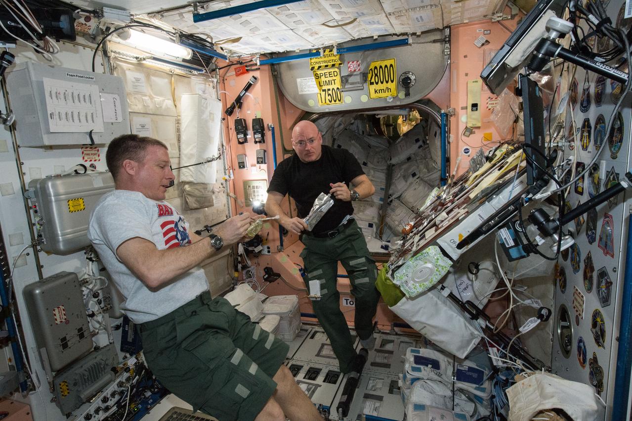 ISS043E086137 (04/04/2015) --- It's mealtime on the International Space Station. NASA astronauts Terry Virts (left) and Scott Kelly (right) take a rest from their duties and enjoy some of the special foods prepared for them to eat while in microgravity.