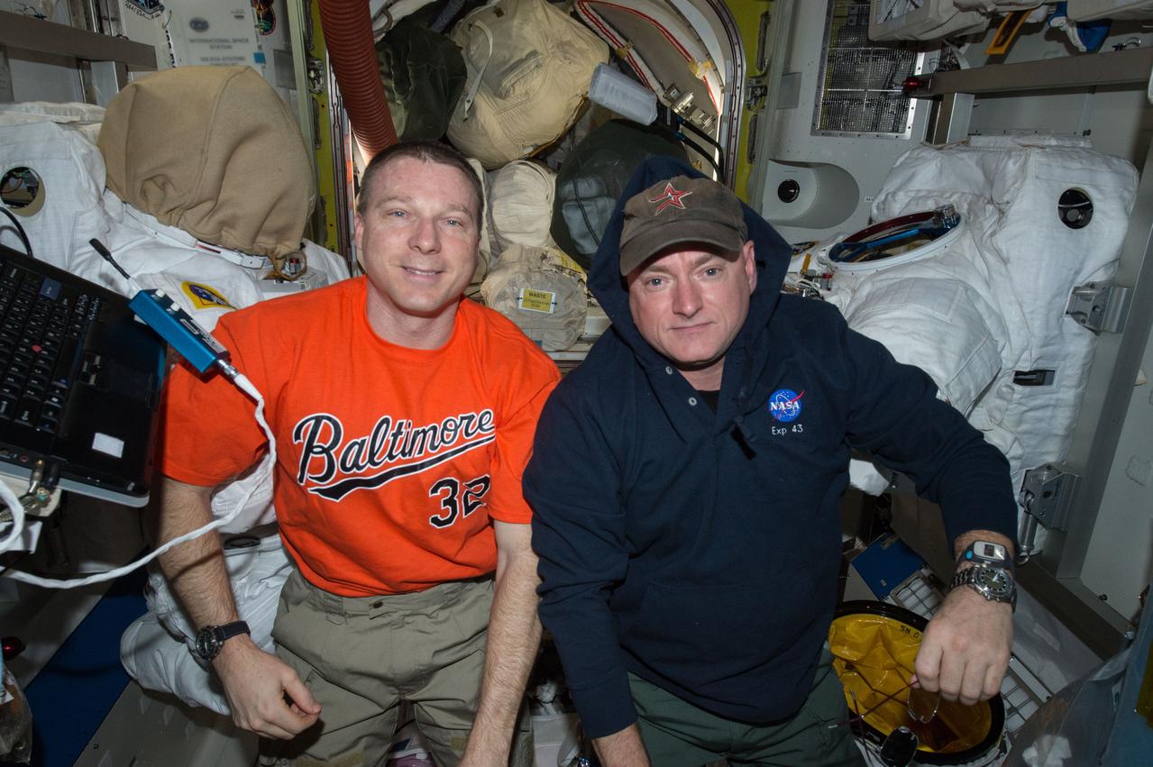 ISS043E087403 (04/06/2015) --- NASA astronauts Terry Virts (left) and Scott Kelly are seen here inside the station’s Quest airlock. The pair were performing routine maintenance activities on two of the International Space Station’s Extravehicular Mobility Units (EMU,) or spacesuits, seen in the background.