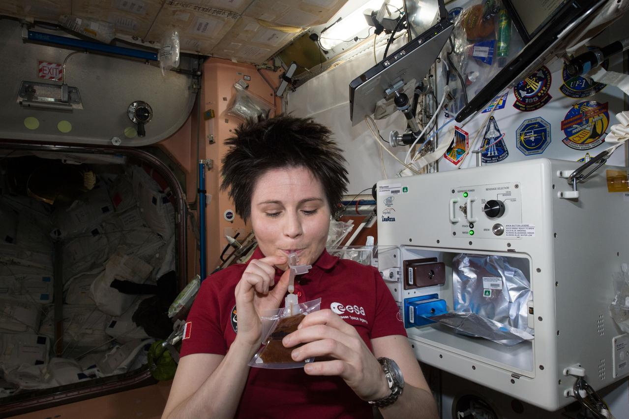 ISS043E160082 (05/03/2015) --- ESA (European Space Agency) astronaut Samantha Cristoforetti enjoys her first drink from the new ISSpresso machine. The espresso device allows crews to make tea, coffee, broth, or other hot beverages they might enjoy.
