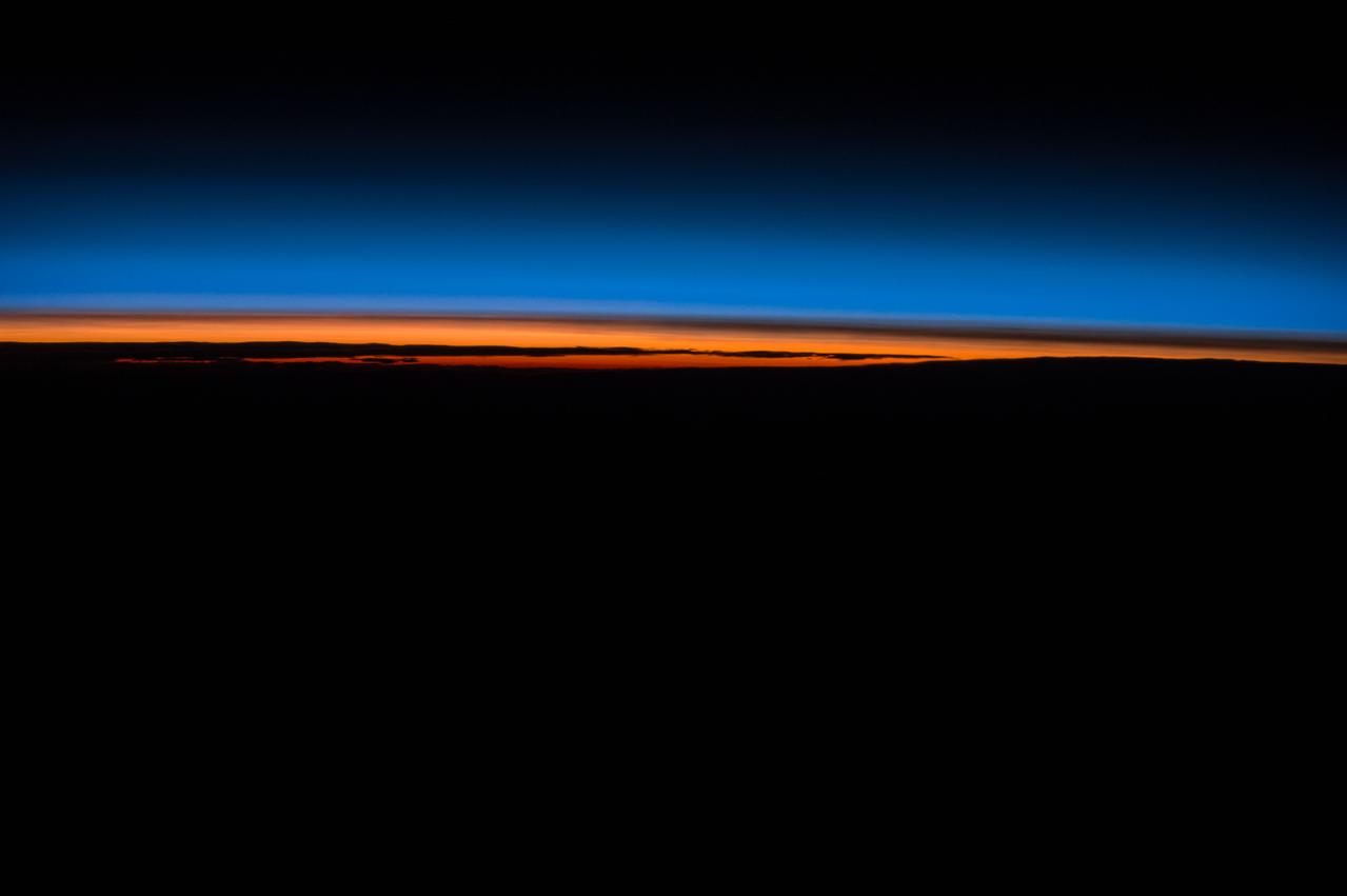 ISS043E193911 (05/14/2015) --- Crew members of Expedition 43 on the International Space Station are treated to the spectacular beauty of the Earth day and night. In this image they captured the dying sun as it creates brilliant orange and red streaks contrasted with the darkening Earth and the still blue night sky.