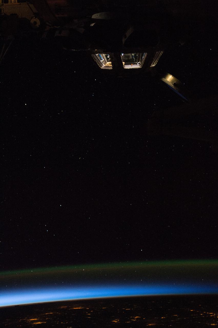 ISS043E249148 (05/23/2015) --- As the day begins on the International Space Station the cupola, the 360 degree view port's inner lights shine brightly while the sun begins its rise slowly on the Earth below. The cupola is a panoramic control tower for the station with windows through which operations on the outside of the station can be observed and guided. Through the robotics workstation, astronauts are able to control the space station's robotic arm, which helps with the attachment and assembly of various station elements, very much like the operator of a building crane. Spacewalking activities can also be observed from the Cupola along with visiting spacecraft and external areas of the station.
