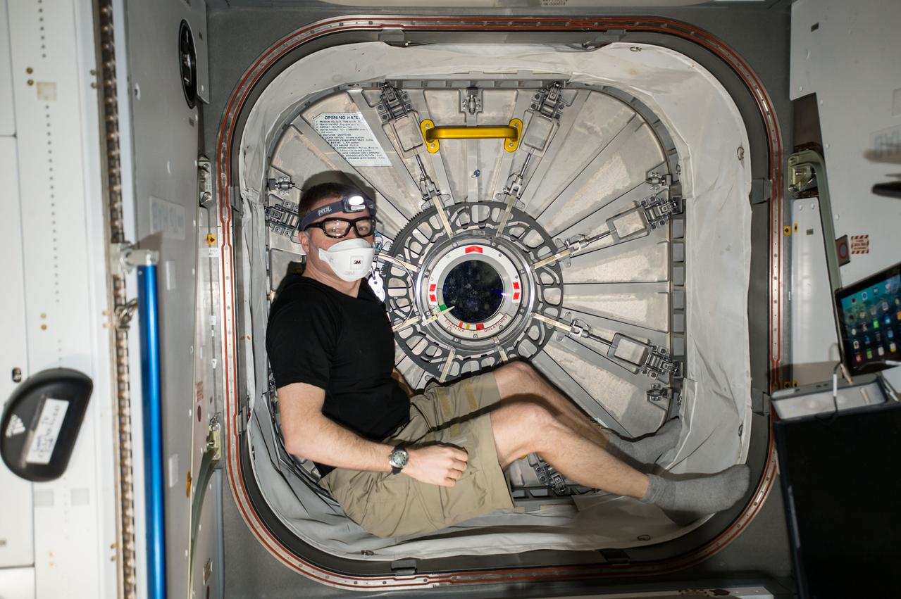 ISS043E266841 (05/28/2015) --- Expedition 43 Commander and NASA astronaut Terry Virts sits is one of the hatchways aboard the International Space Station following the relocation of the Leonardo Permanent Multipurpose Module (PMM.) The PMM was relocated from the Unity node to the Tranquility node as the next step in preparing the International Space Station for the installation of new International Docking Adapters which will enable future U.S. commercial crew vehicles to dock to the station. Crew members typically wear personal protective devices (mask, glasses, gloves) whenever opening a hatch following dynamic operations as a precaution.