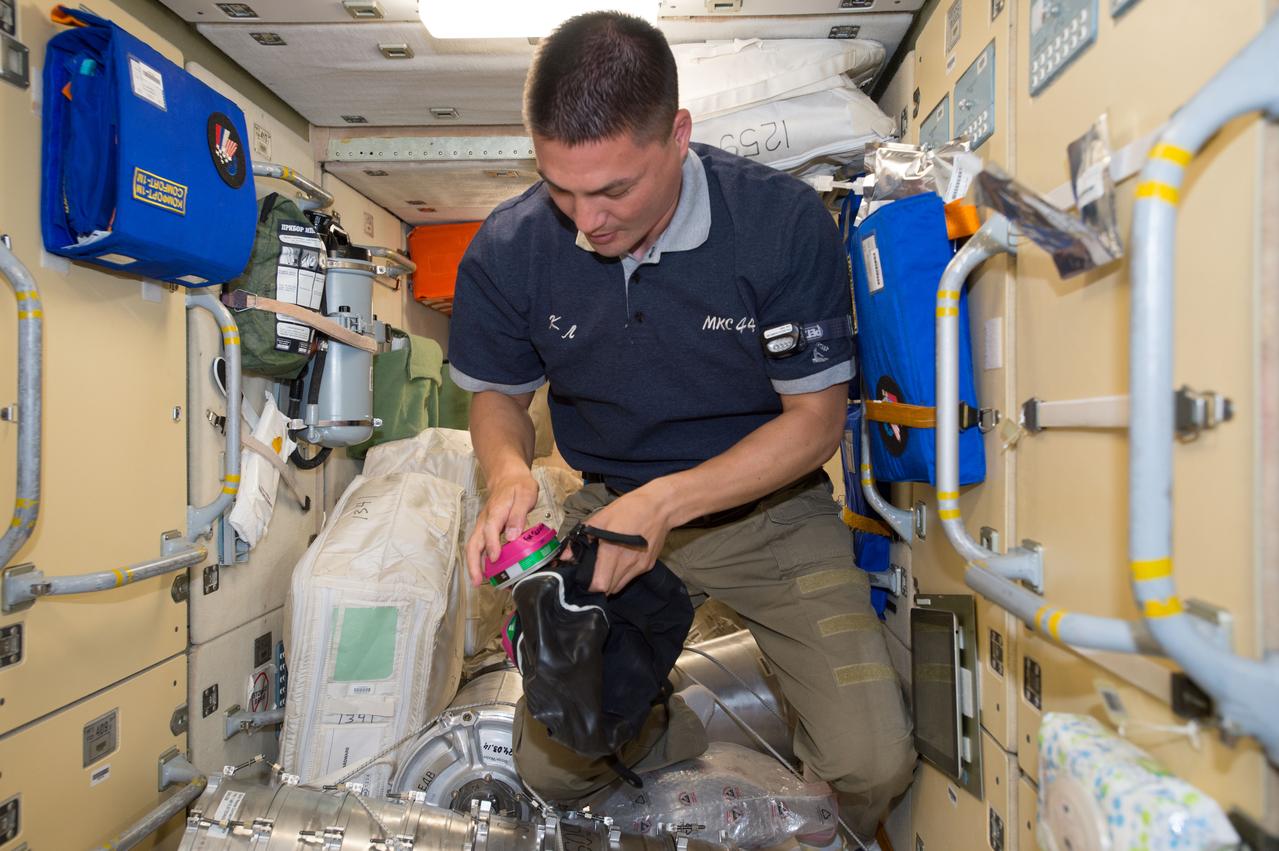ISS044E025035 (07/29/2015) --- NASA astronaut Kjell Lindgren prepares to don protective breathing apparatus that would be used in the unlikely event of a fire or hazardous chemical leak inside the pressurized air volume of the International Space Station. Familiarization of safety and emergency equipment is standard practice for all newly arrived crew members.