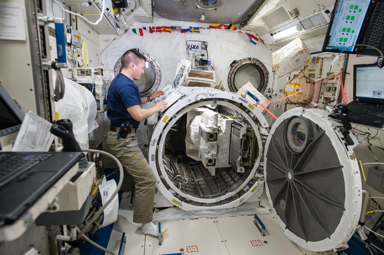 ISS045E033806 (09/25/2015) --- NASA astronaut Kjell Lindgren loads a deployer device filled with 16 CubeSats into a small airlock in the Japanese Kibo Module on the International Space Station. Among the 16 satellites are 14 Dove satellites from Planet Labs that will be used for Earth observation, one for testing space based radios and another that will be used to track ships on the open ocean.