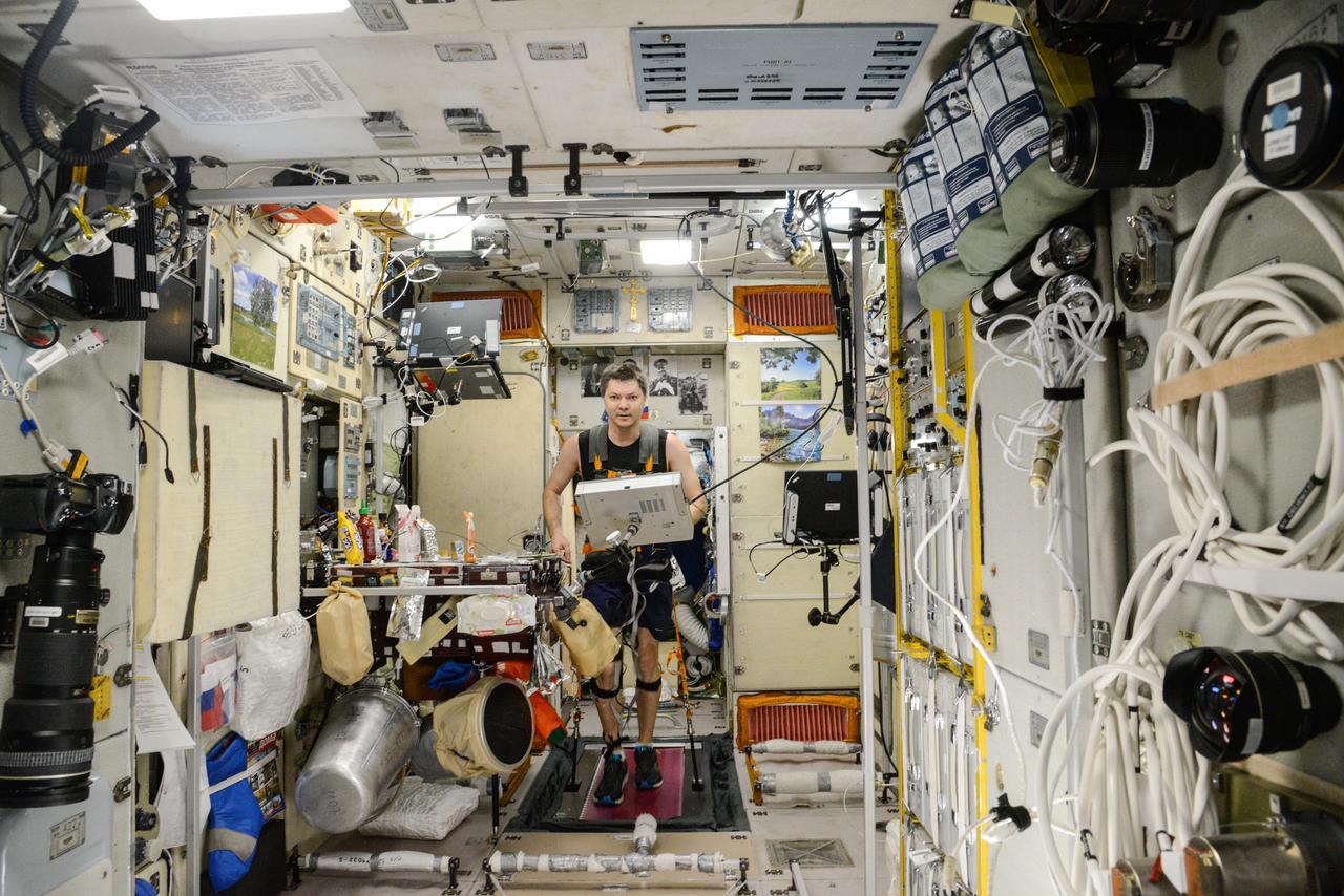 iss045e082560 (10/28/2015) --- Roscosmos cosmonaut Oleg Kononenko, wearing a harness and electrodes, is photographed during Motocard experiment operations in the Zvezda Service Module (SM) aboard the International Space Station (ISS). The Mechanisms of Sensory-Motor Coordination in Weightlessness (Motocard) investigation is carried out on the treadmill and involves locomotion in various modes of running and walking during various modes of operation of the treadmill. During the test, electromyography of the thigh and calf muscles, support structure response, heart rate, and treadmill load parameters (actual speed, time elapsed, distance, integrated indicators for support structure response) are recorded.