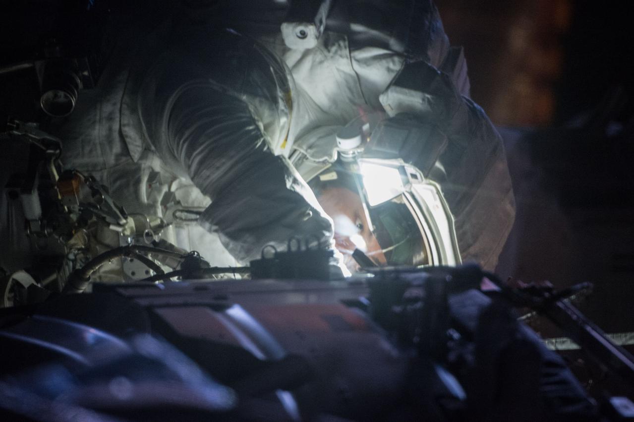 ISS045E082789 (10/28/2015) --- NASA astronaut Kjell Lindgren is photographed through a window during a night pass while on his first spacewalk on Oct. 28, 2015. Lindgren and NASA astronaut Scott Kelly worked outside for seven hours and 16 minutes on a series of tasks to service and upgrade the International Space Station. They wrapped a dark matter detection experiment in a thermal blanket, lubricated the tip of the Canadarm2 robotic arm and then routed power and data cables for a future docking port.