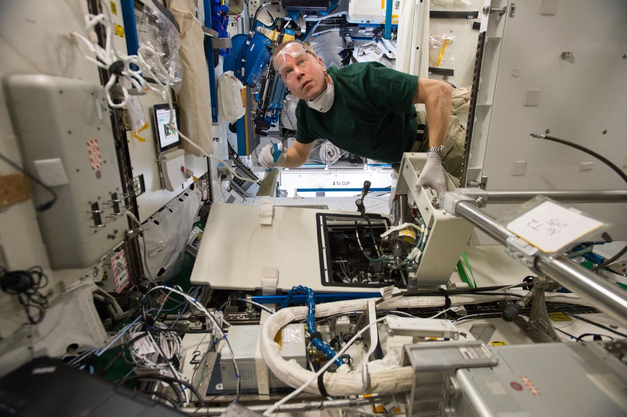 ISS046e023885 (01/25/2016) --- NASA astronaut Tim Kopra performs regular maintenance on the Urine Processing Assembly (UPA) aboard the International Space Station. The UPA is used by the crew to recycle water for use on the station. The image shows Tim replacing the brine filter from the UPA Fill Drain Valve enclosure.