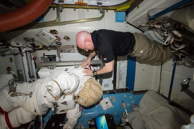 NASA image: NASA astronaut Scott Kelly relocates spacewalk hardware and suits inside the Quest airlock