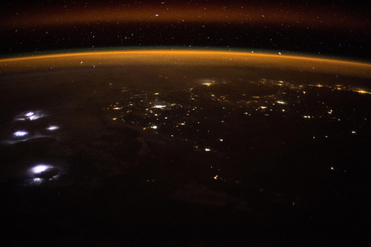ISS047e007765 (03/14/2016) --- Using special cameras and Chronophotography aboard the International Space Station, crew members of Expedition 47 during Earth observations capture awesome beauty . This nighttime image shows an approaching lightning storm on the left. The gold and red aurora act as a frame to this display of natures wonders.