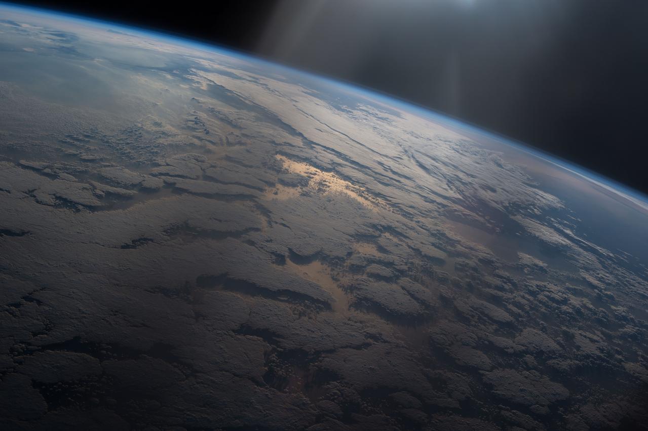 ISS047e016259 (03/24?2016) --- A beam of light shines down on the Earth creating a golden reflection off the water in this image captured by the crew of Expedition 47 on the International Space Station.