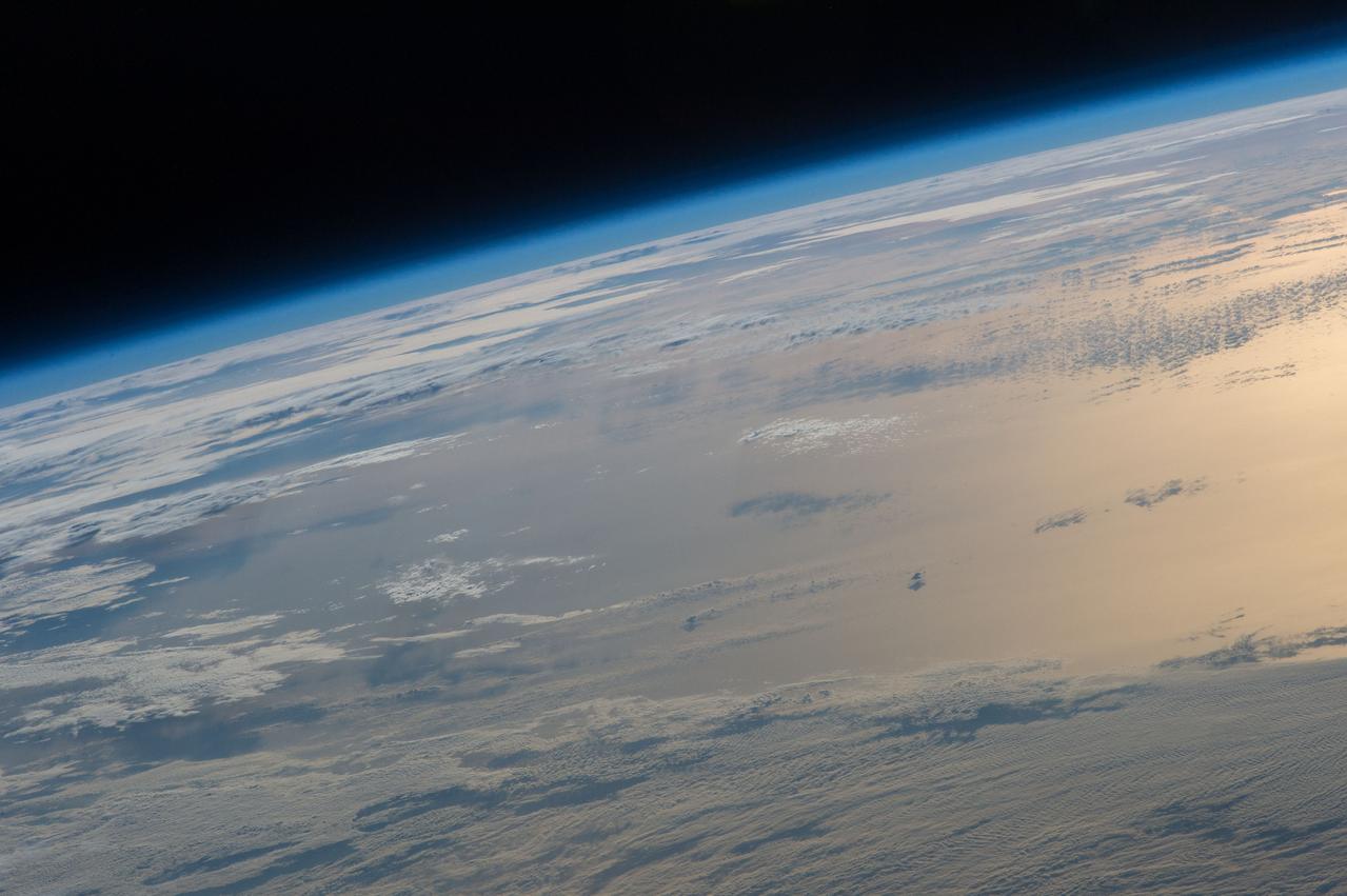 ISS047e020123 (03/25/2016) --- A golden reflection of the rising sun on the Earths oceans greets the crew of Expedition 47 on board the International Space station. Another day begins for the crew in their pursuit of science that will aid humankind.