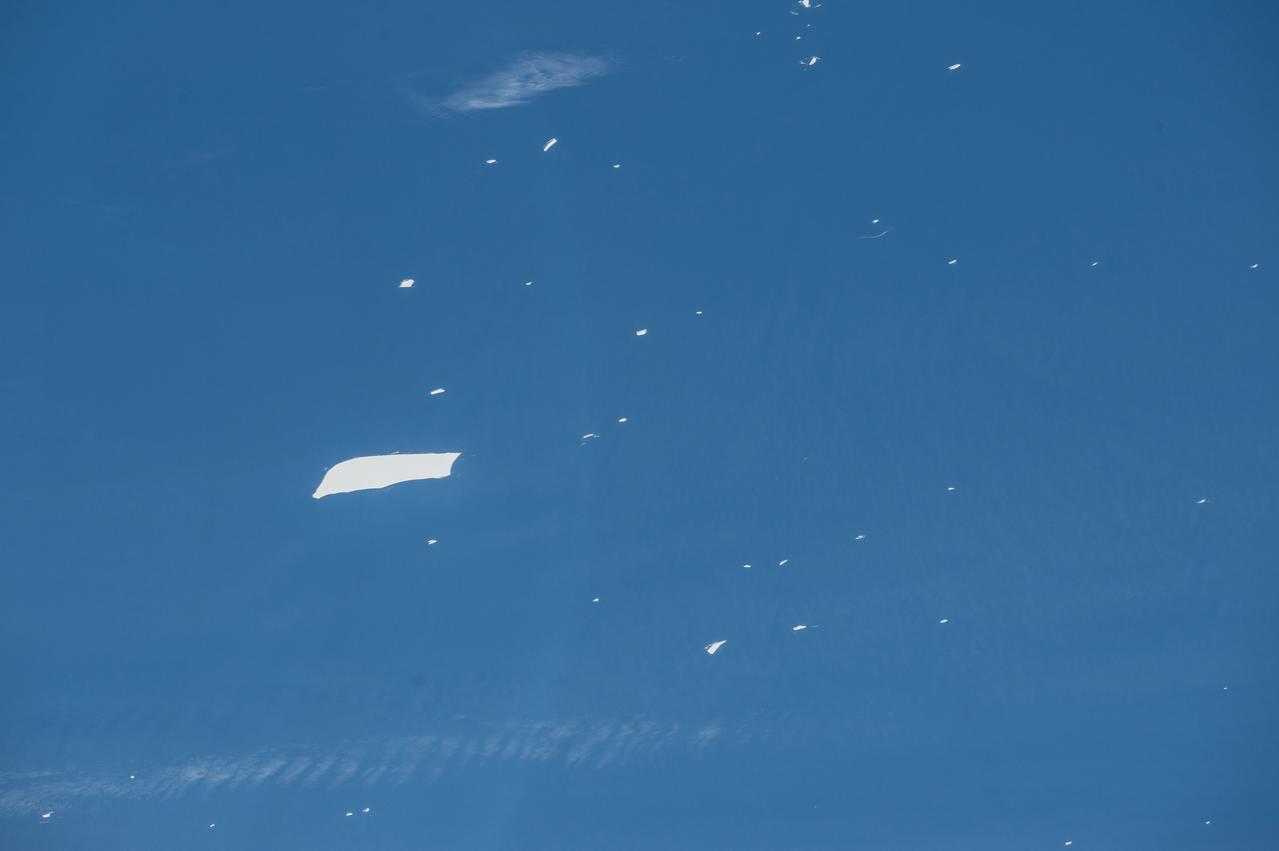 ISS047e22133 (03/27/2016) ---The crew of Expedition 47 aboard the International Space Station captured this image of a massive iceberg causing shipping to pay close attention. It is floating in the southern Atlantic Ocean, near the South Georgia and South Sandwich Islands. Smaller pieces cluster around the main iceberg. causing further shipping concern. The closest continent is the bottom tip of South America (Argentina) and the Falkland Islands.