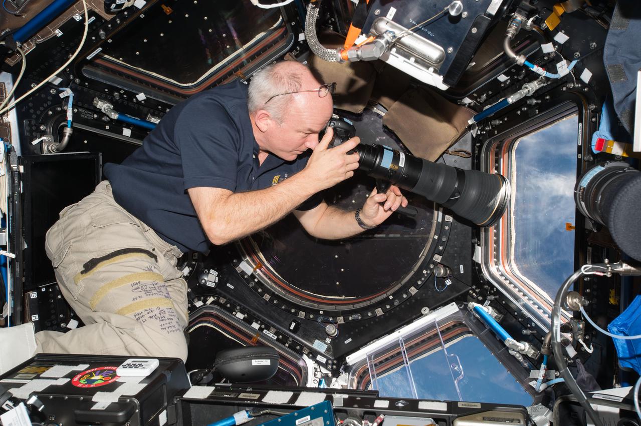 iss047e142181 (6/6/2020) --- NASA astronaut Jeff Williams taking photographs of the earth for the At Home in Space investigation. This photo was taken in the Cupola to capture the International Space Station (ISS) culture, which includes anything that makes the ISS your home.
