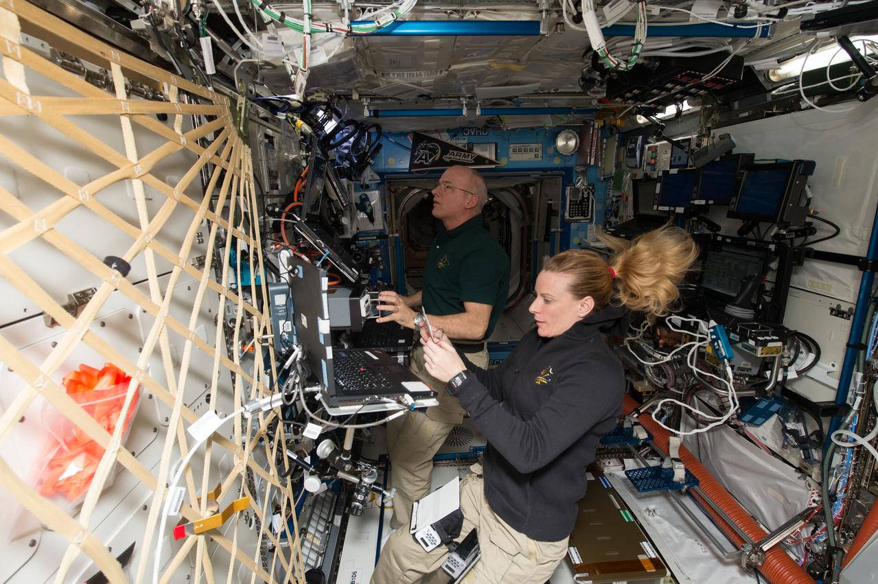 ISS048e028558 (07/18/2016) --- NASA astronauts Jeff Williams (left) and Kate Rubins (right) train inside the Destiny laboratory for the robotic capture of SpaceX’s Dragon spacecraft. Williams was the primary robotic arm operator and Rubins supported from a backup role.