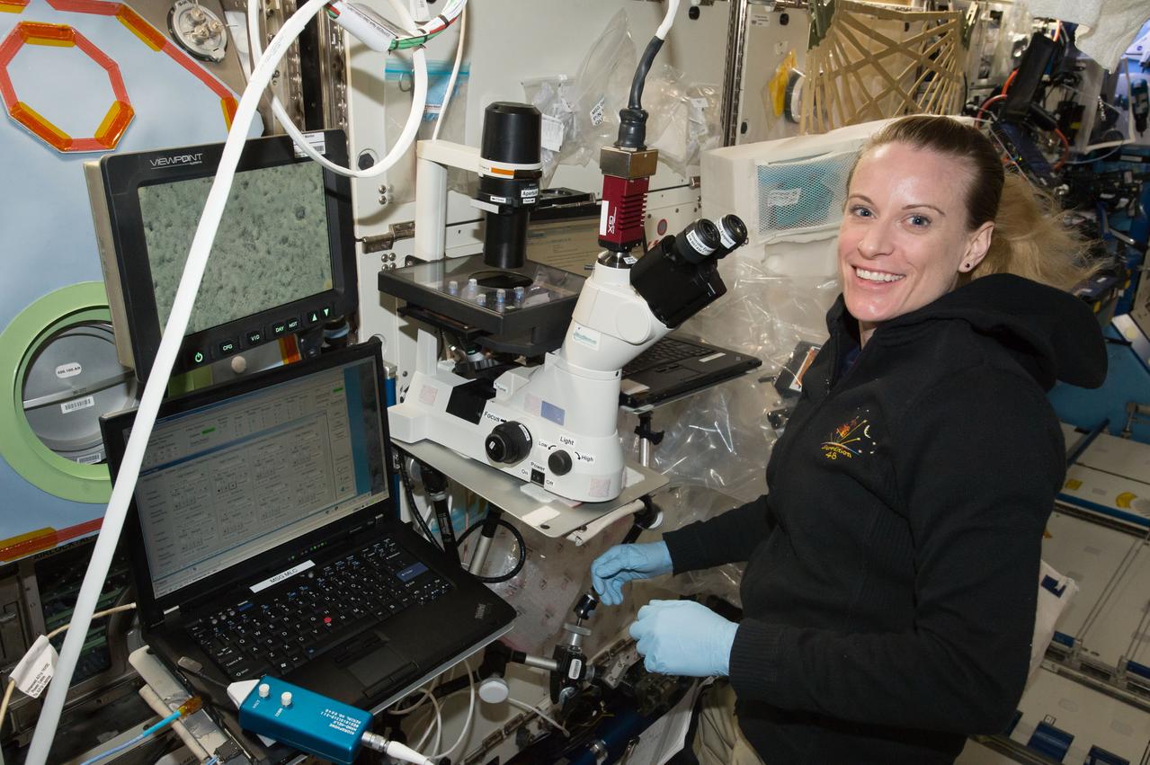 iss048e045065 (7/27/2016) --- NASA astronaut Kate Rubins pauses for a photo while using the Microscope to conduct Heart Cells experiment operations. Effects of Microgravity on Stem Cell-Derived Cardiomyocytes (Heart Cells) studies the human heart, specifically how heart muscle tissue, contracts, grows and changes (gene expression) in microgravity and how those changes vary between subjects.