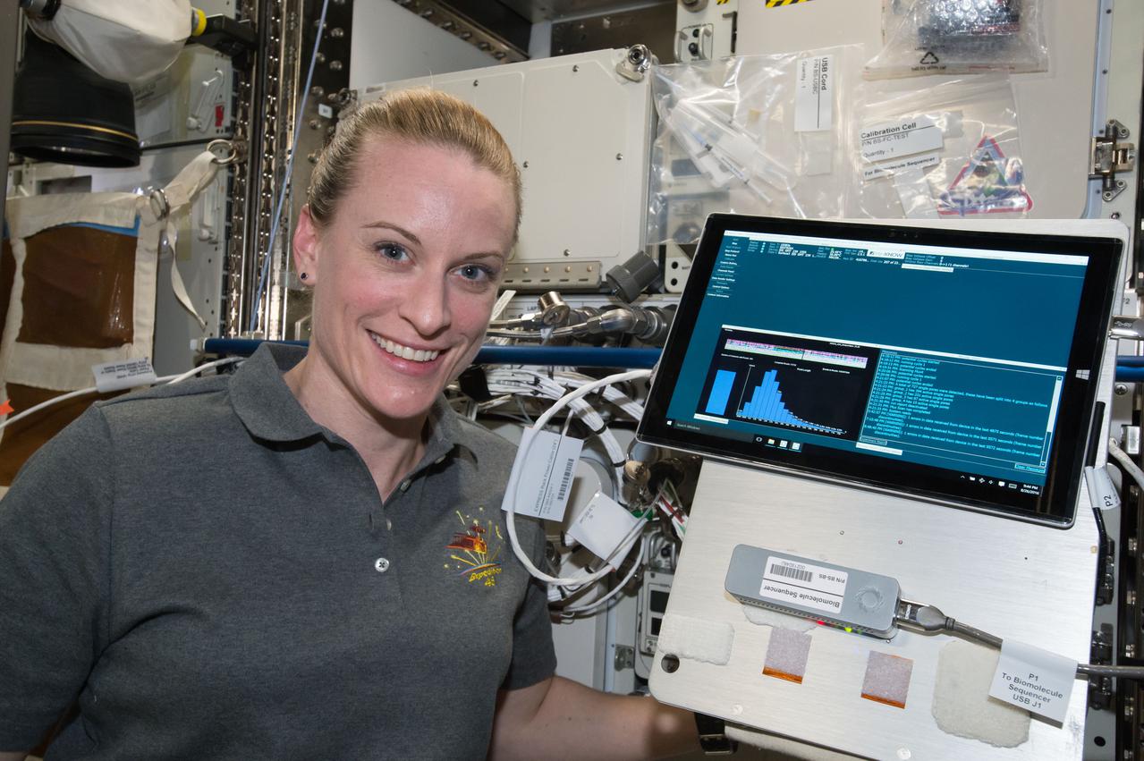 iss048e066523 (8/26/2016) --- NASA astronaut Kate Rubins poses for a photo with Biomolecule Sequencer experiment hardware (Surface Pro 3 tablet and MinION) during the first sample initialization run. The image was taken in the Destiny U.S. Laboratory aboard the International Space Station (ISS).