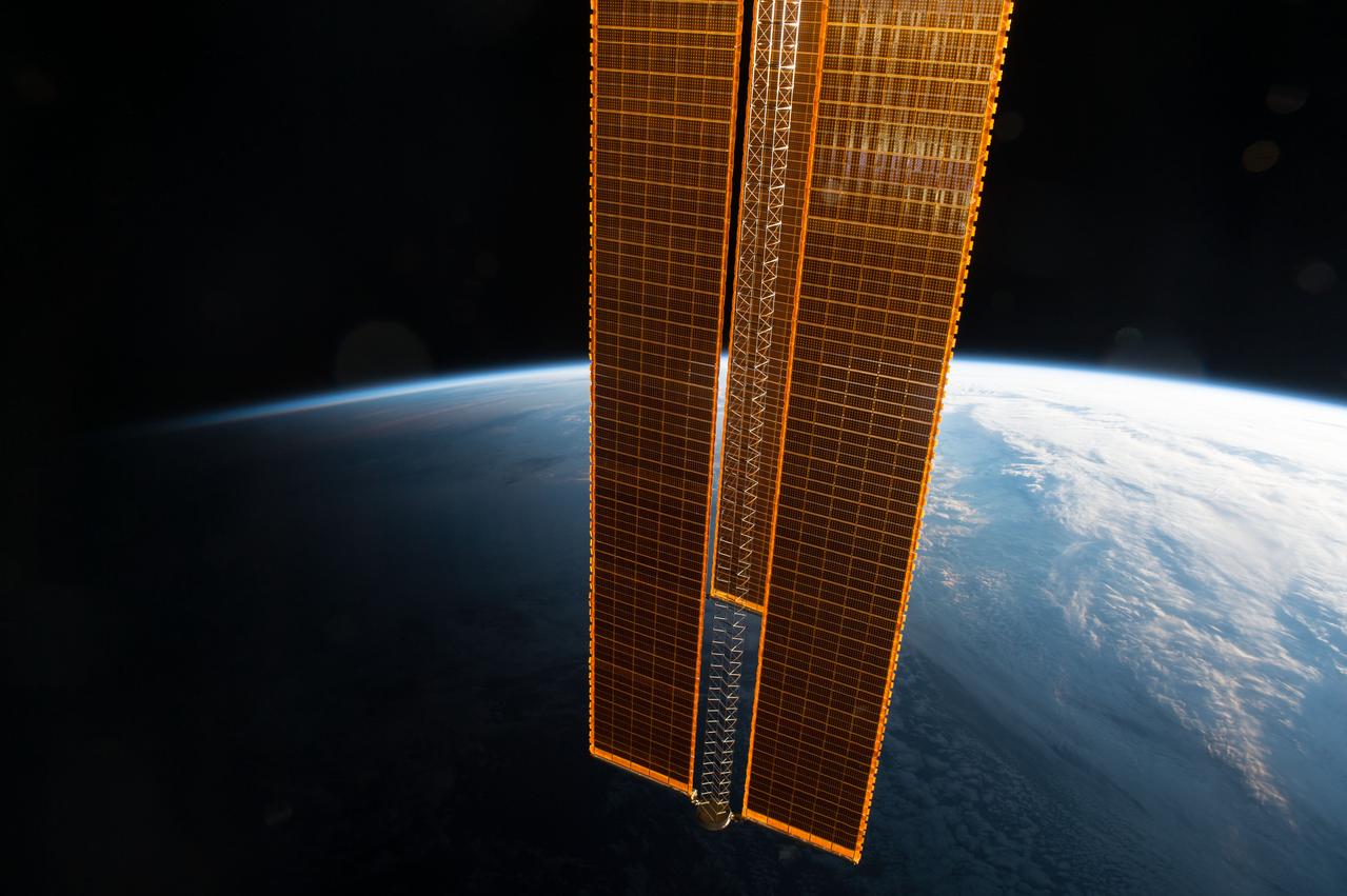 View of golden solar array with Earth limb in the background taken by the Expedition 49 crew.